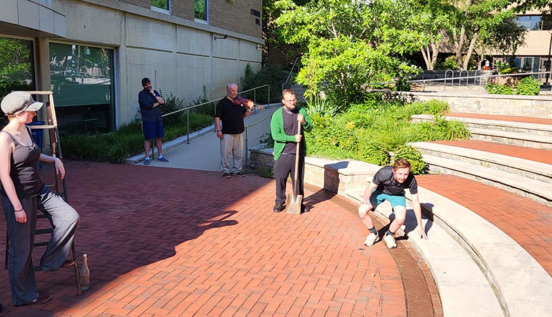 Actors outside the Library (Columbus Hall) during a dress rehearsal on July 12, Halen Hartman leans on a ladder, then, left to right from the background, Scott Douglas Wilson, Mark Mann, Cody Gatewood, and Jayce Caleb Rentrop.