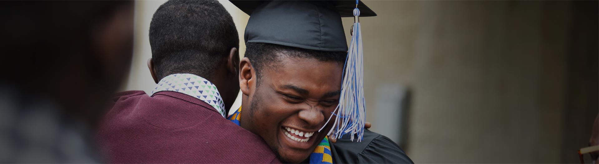 Portrait of graduate teen latin boy student in black graduation